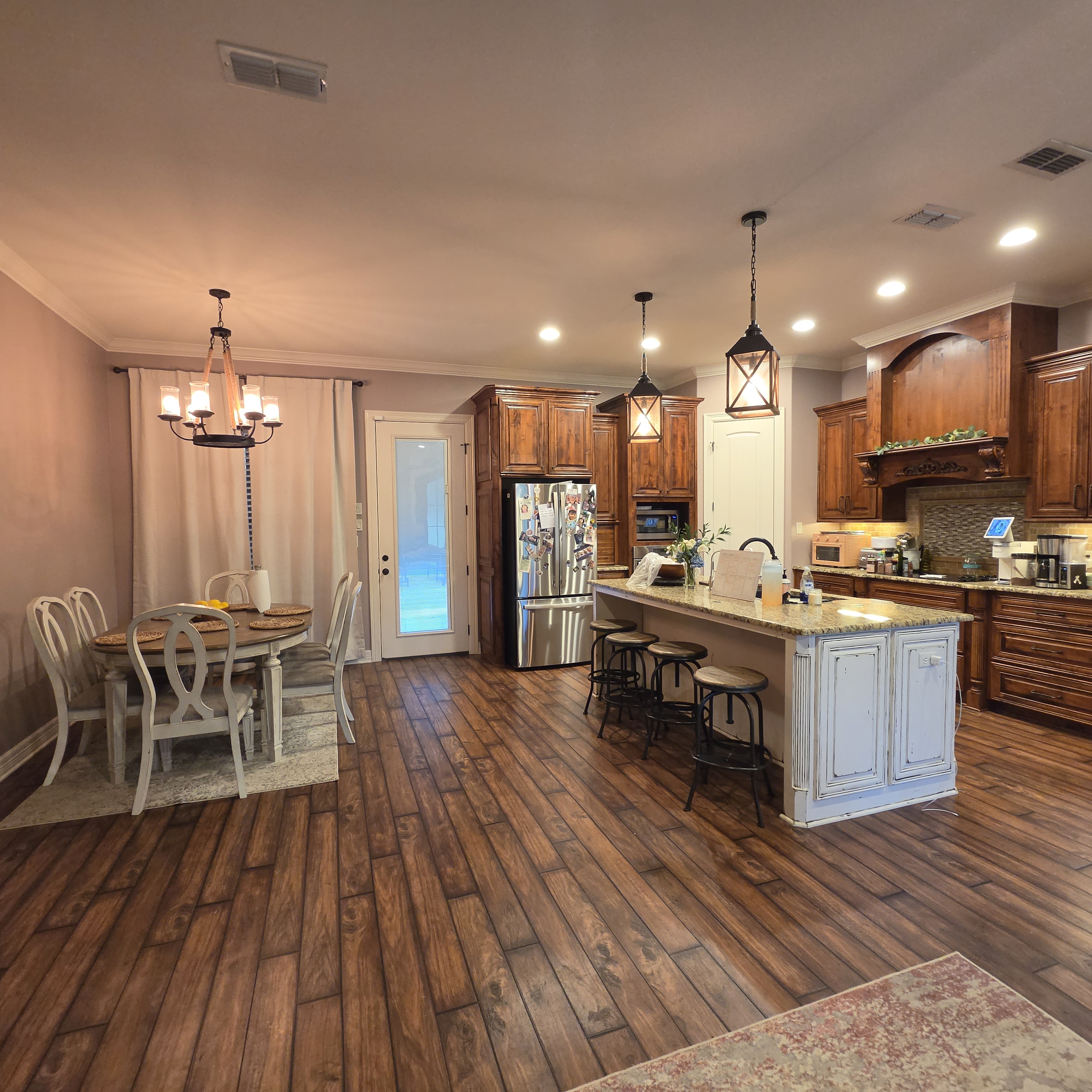Kitchen and dining area with warm neutral walls, wood cabinetry, and a white island